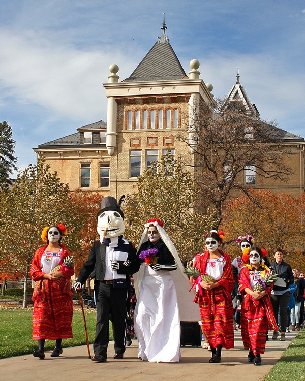 Participants marching in the Day of the Dead procession at USU.