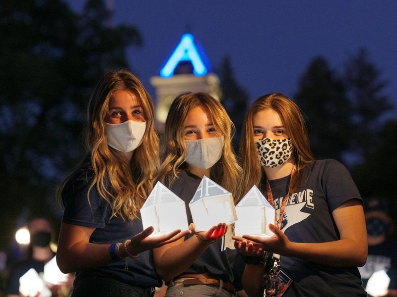 Three USU female students hold their lanterns at the annual Connections Week Luminary.