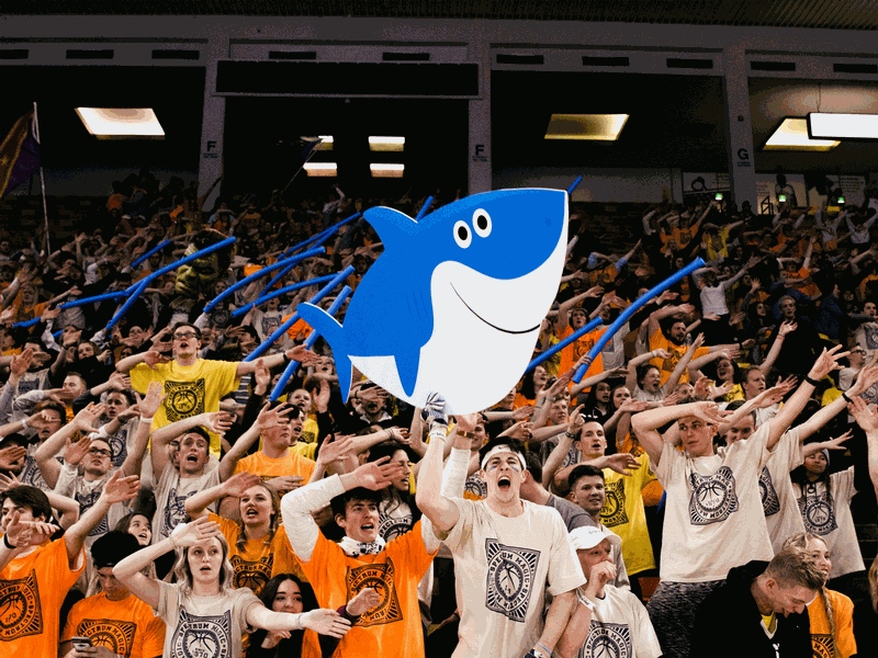 The HURD (USU student section) chanting with a giant shark cutout at the Spectrum Magic Night game.