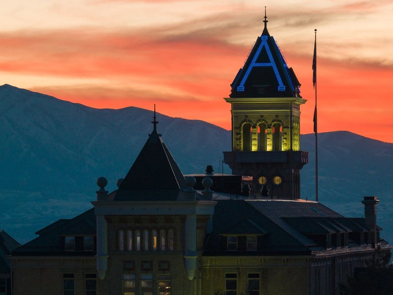 Old Main is illuminated in blue and yellow colors at sunset
