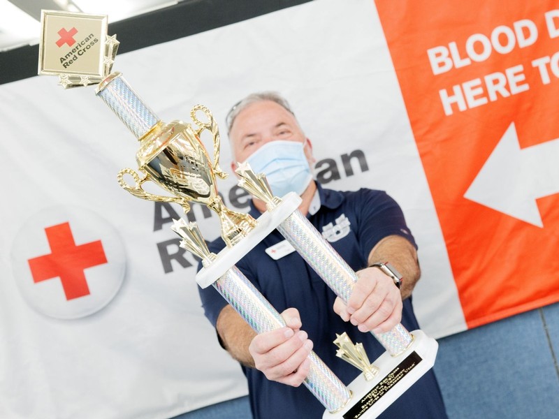 A male USU employee holds up a trophy