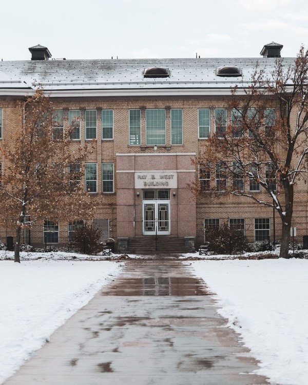 The Ray B. West Building during the day, covered in wet snow