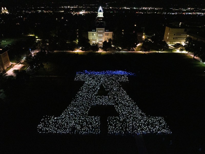 Aerial view of 3,000+ students holding lanterns on the quad at night