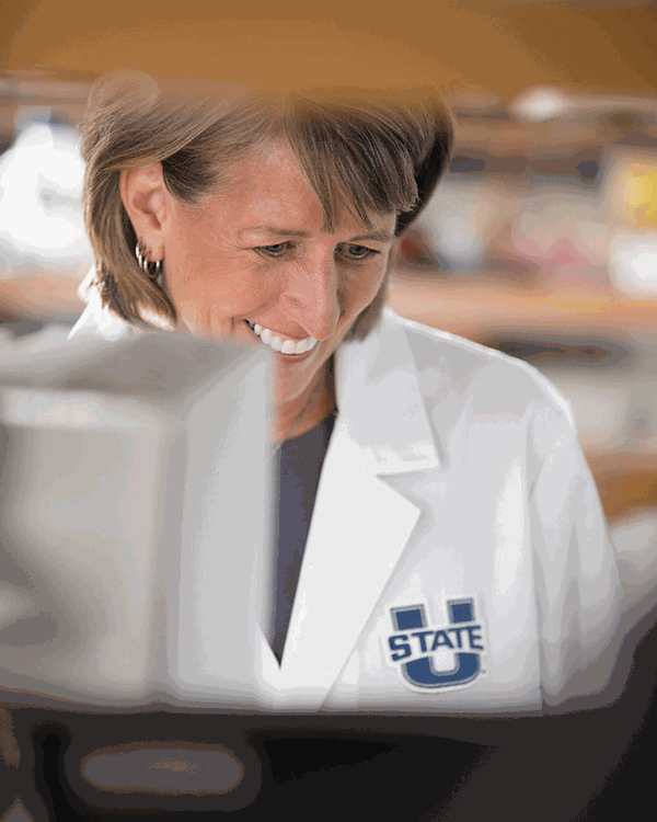 President Cockett smiling as she conducts research in her lab.
