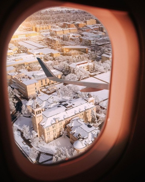 Old Main is visible out of the window of an airplane from above.